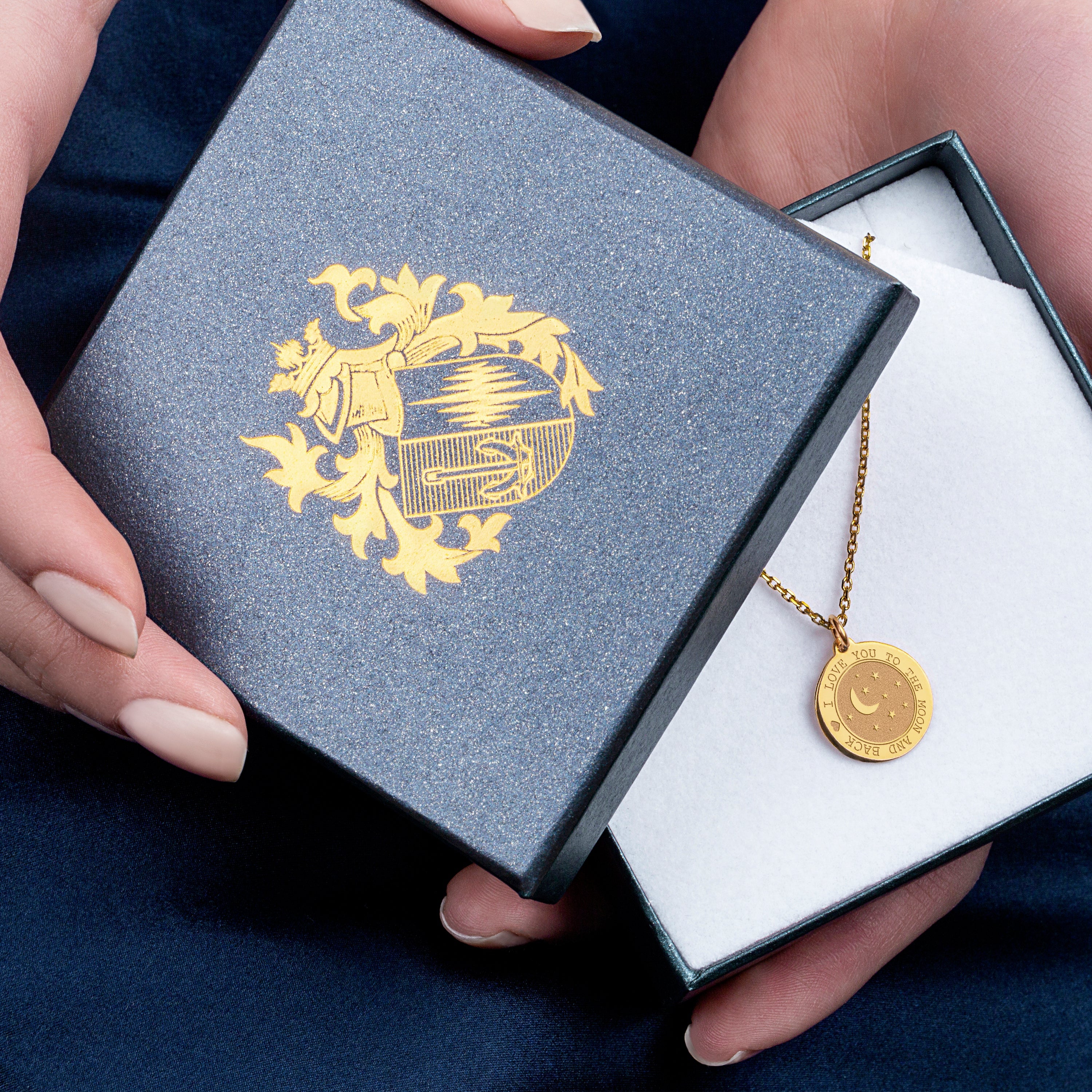 a woman holding a box with a necklace in it